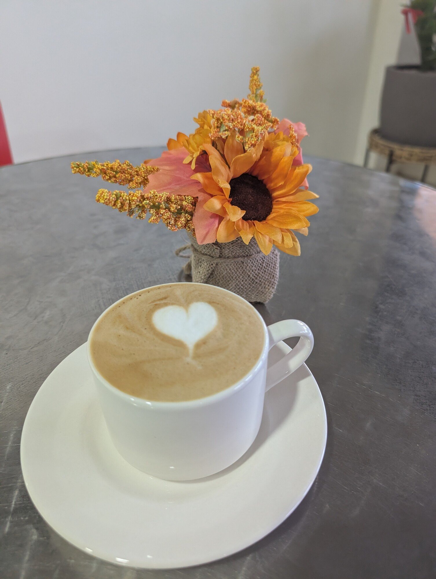 Capuchino con arte latte en forma de corazón sobre una mesa de la cafetería