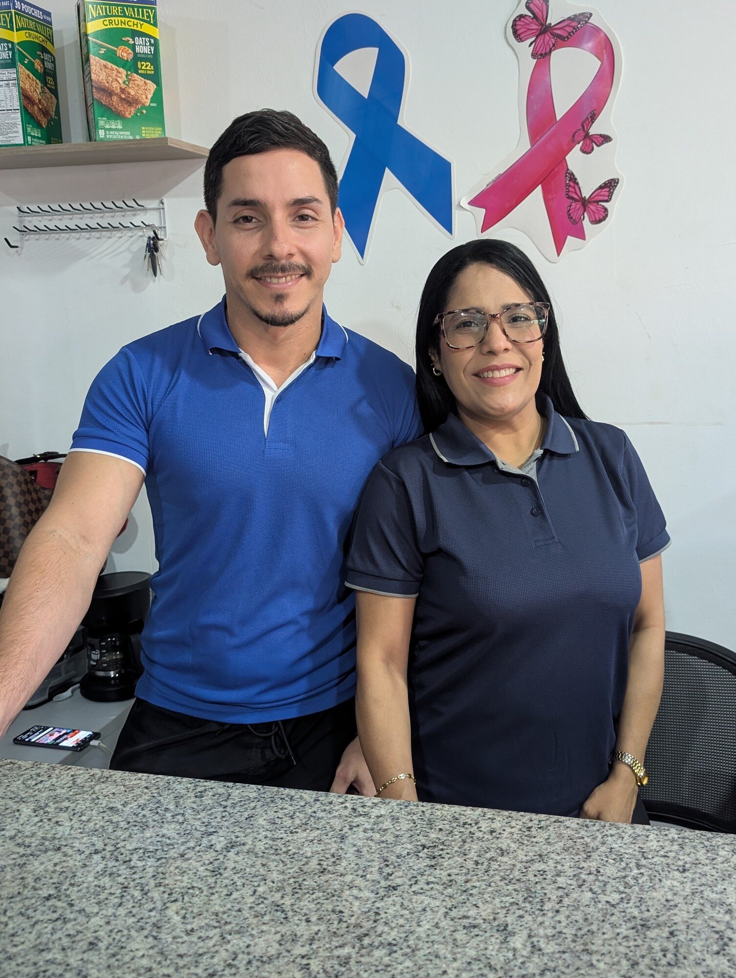 Dos integrantes del equipo de ENERGYM sonríen detrás del mostrador