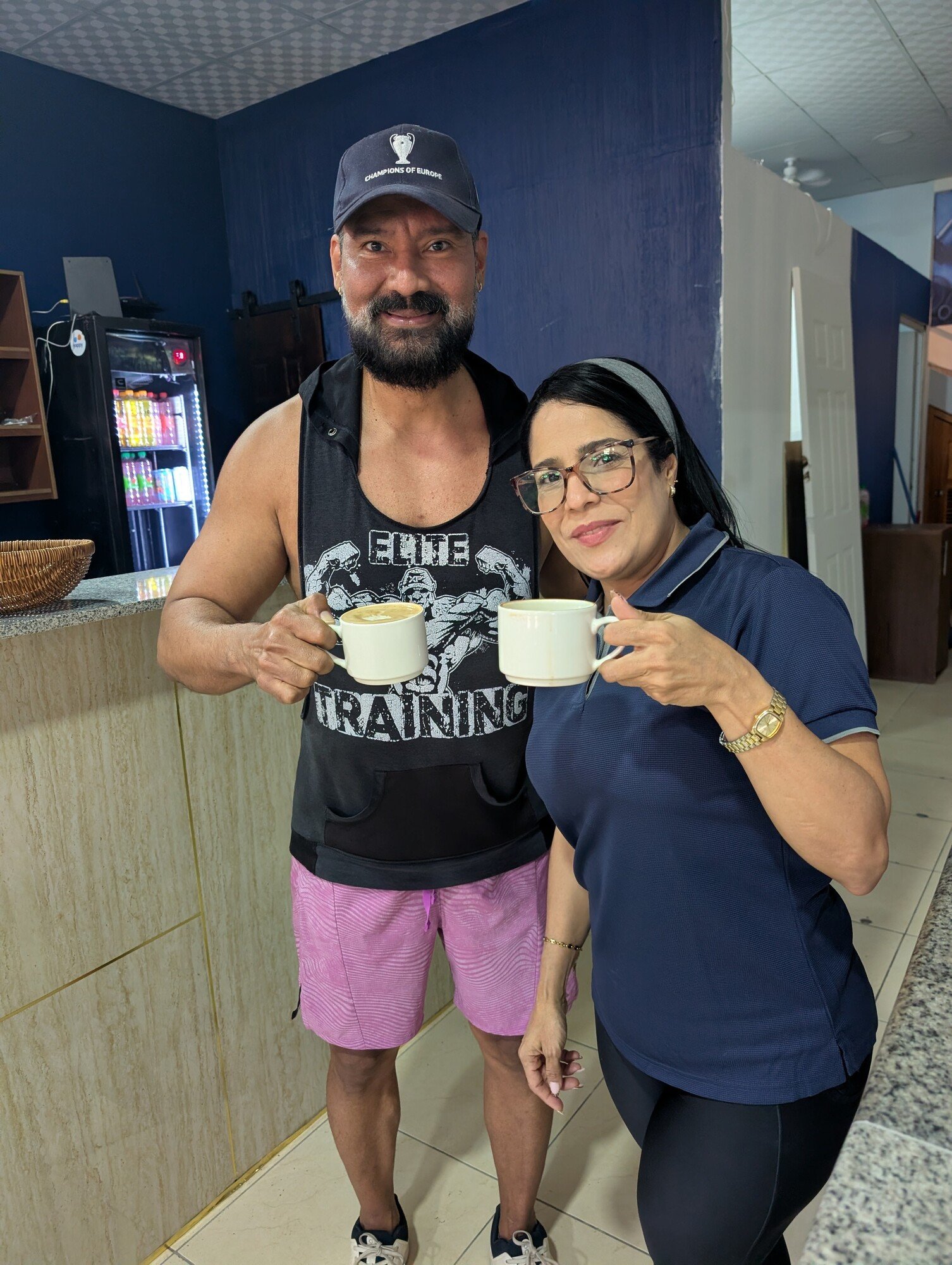 Dos integrantes del equipo de ENERGYM brindan con tazas de café en la cafetería