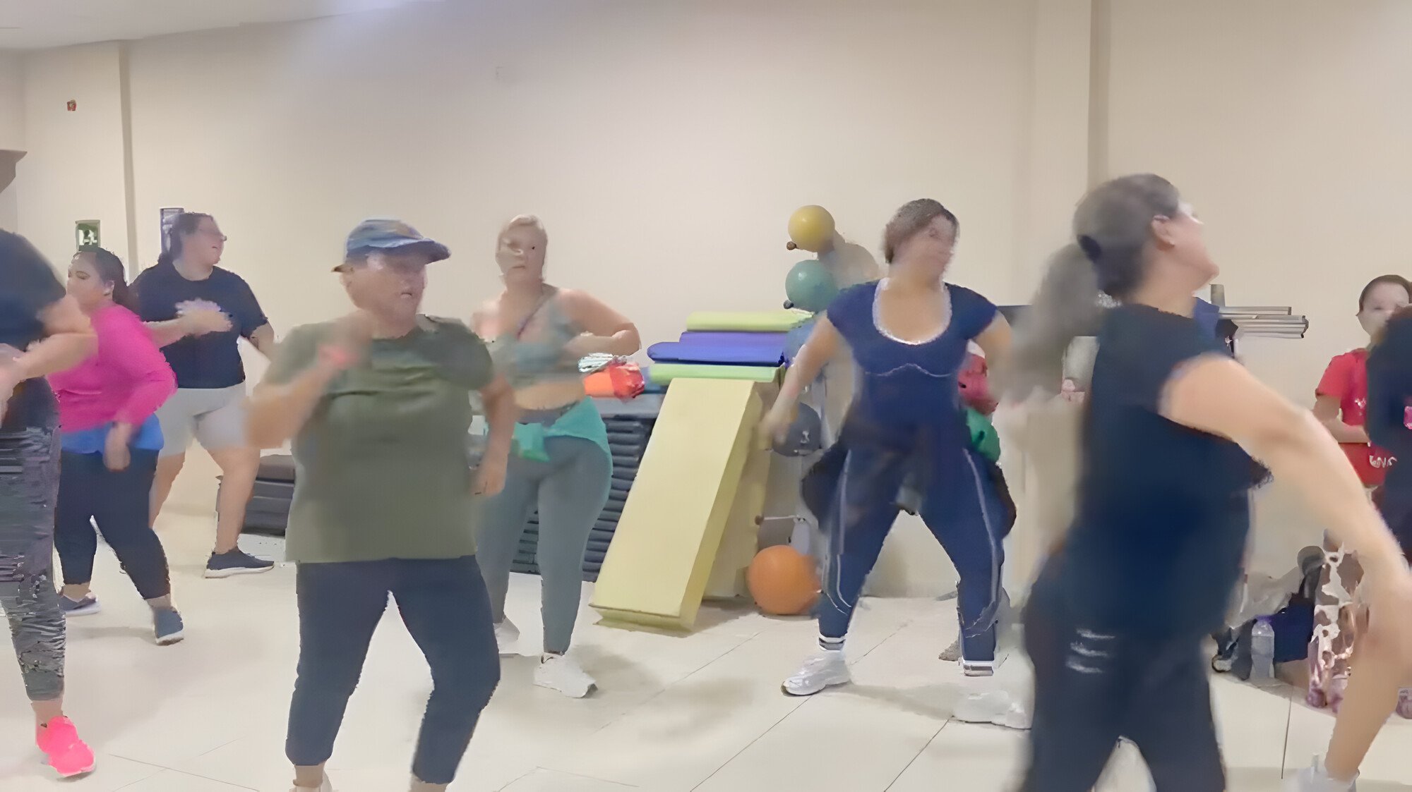 Un grupo de personas baila en una clase de Zumba en la sala de clases